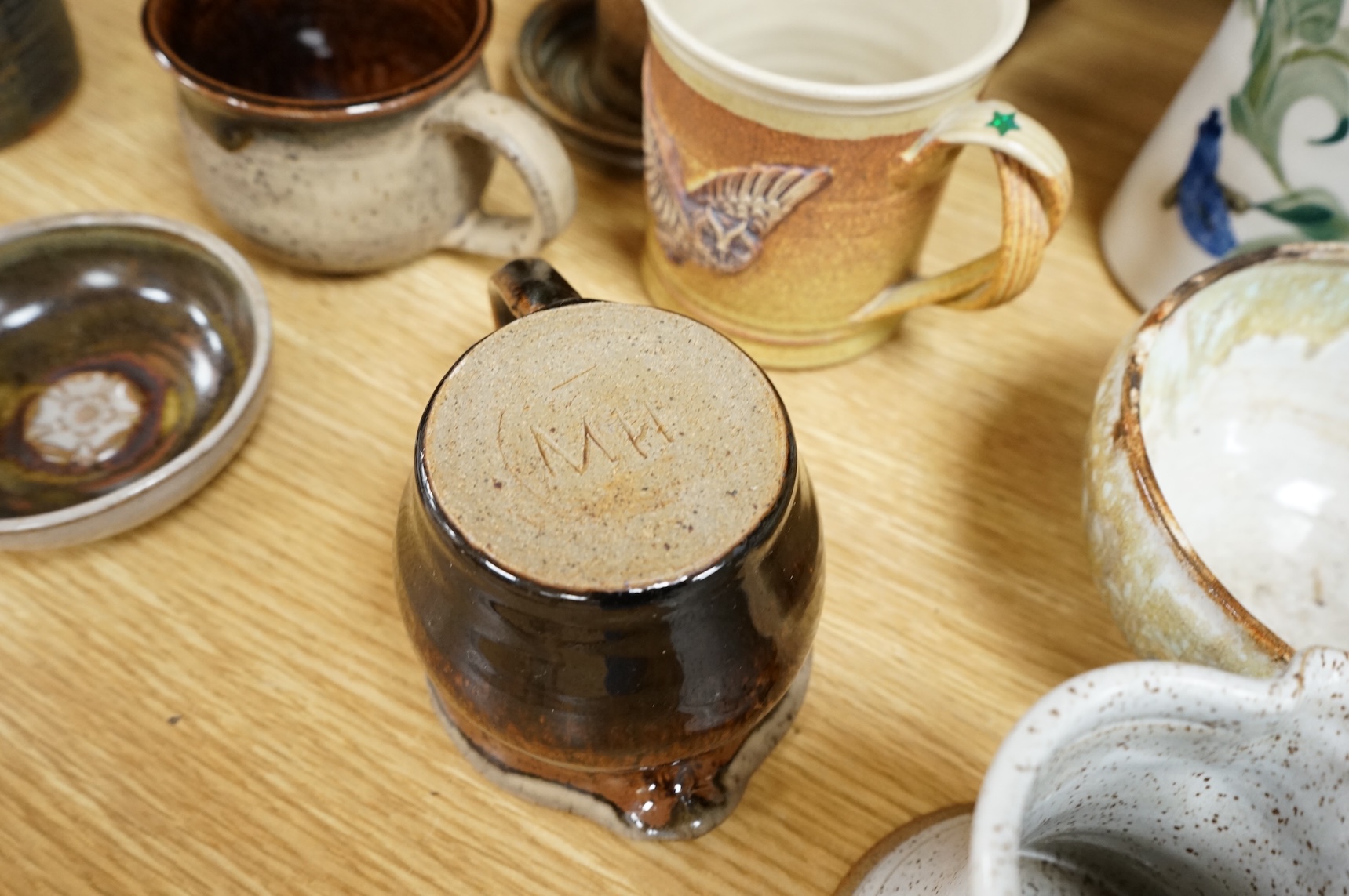 A large collection of studio pottery mugs bowls and jugs, tallest jug 21cm.